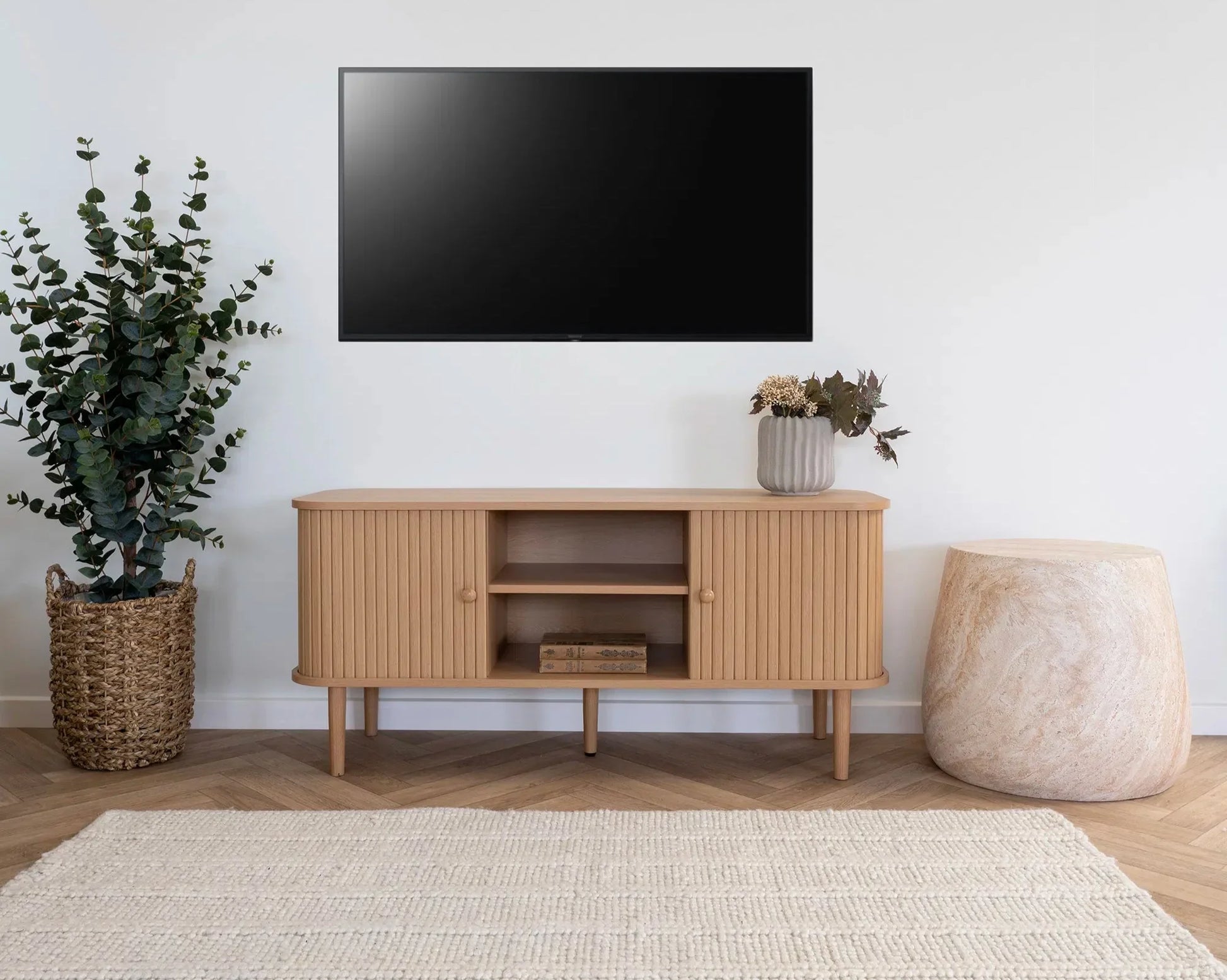 Meuble TV bois clair avec portes rainurées verticalement et pieds fins 113x40 cm
