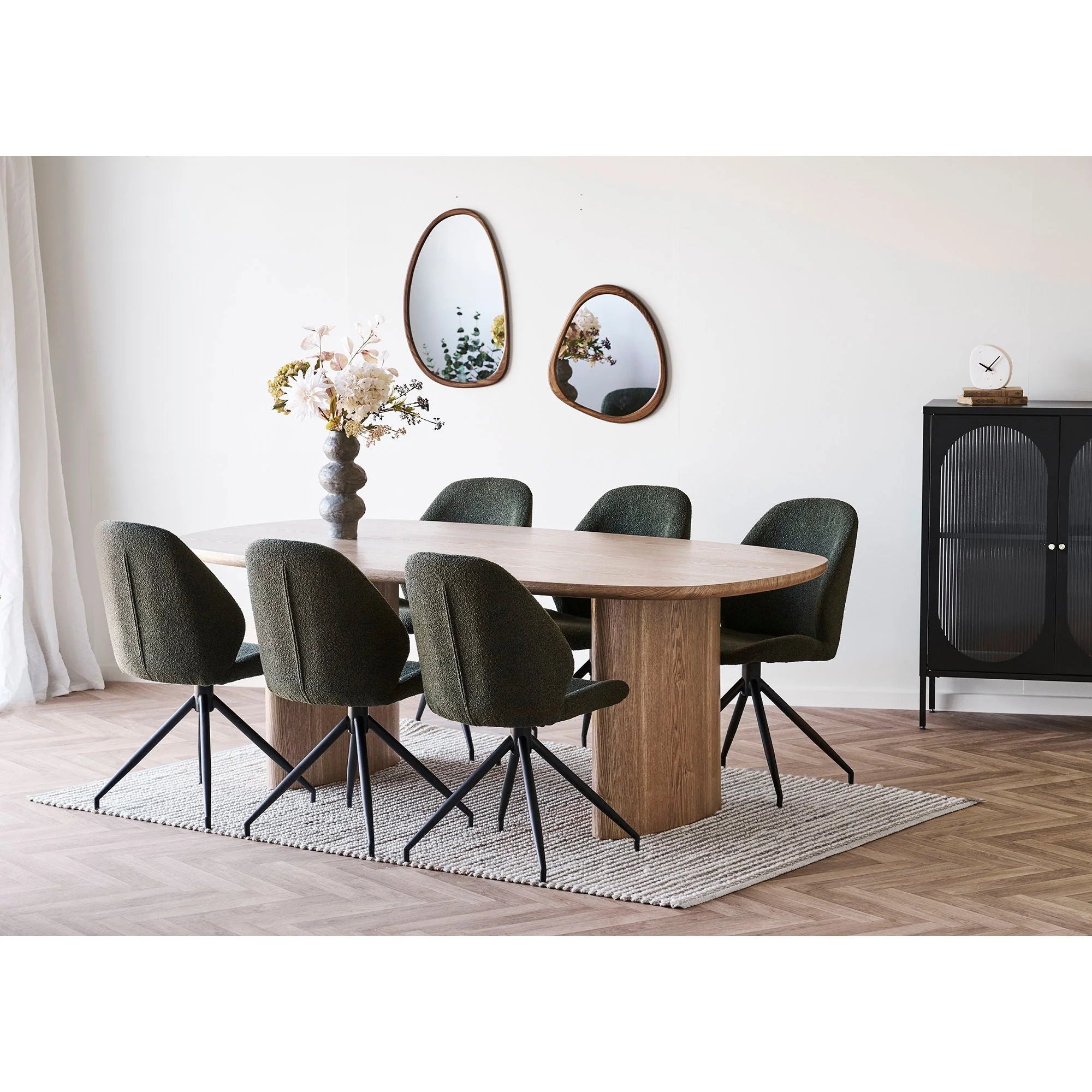Table à manger ovale en bois clair avec six chaises pivotantes vert foncé