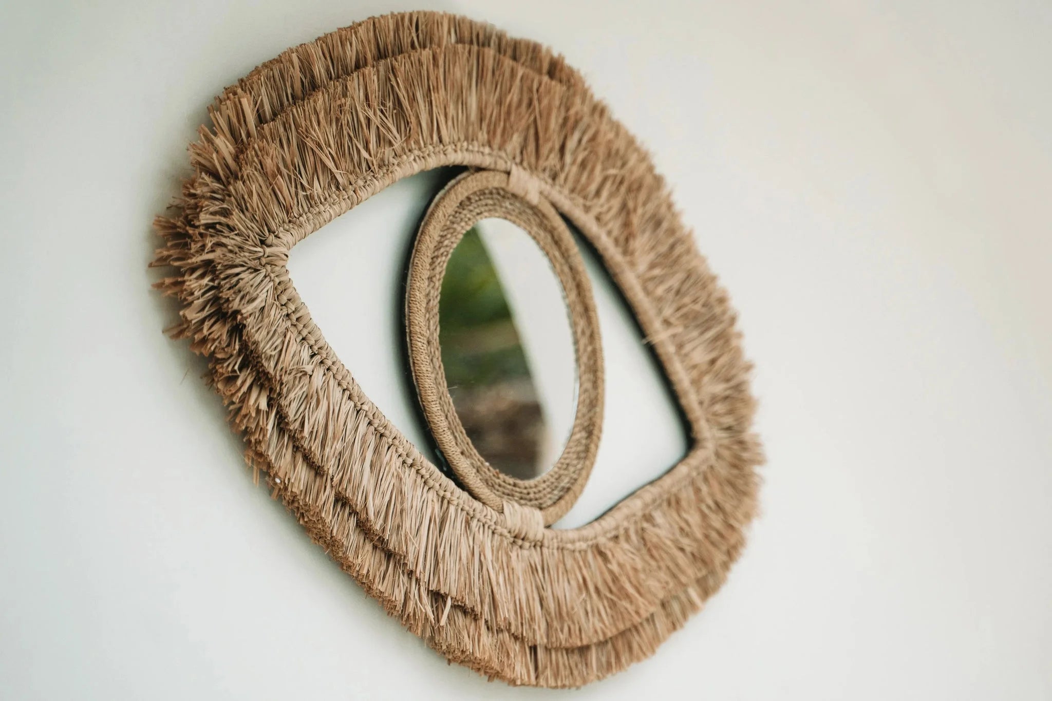 Miroir mural en raphia en forme d’œil avec cadre en fibres naturelles 70x40 cm