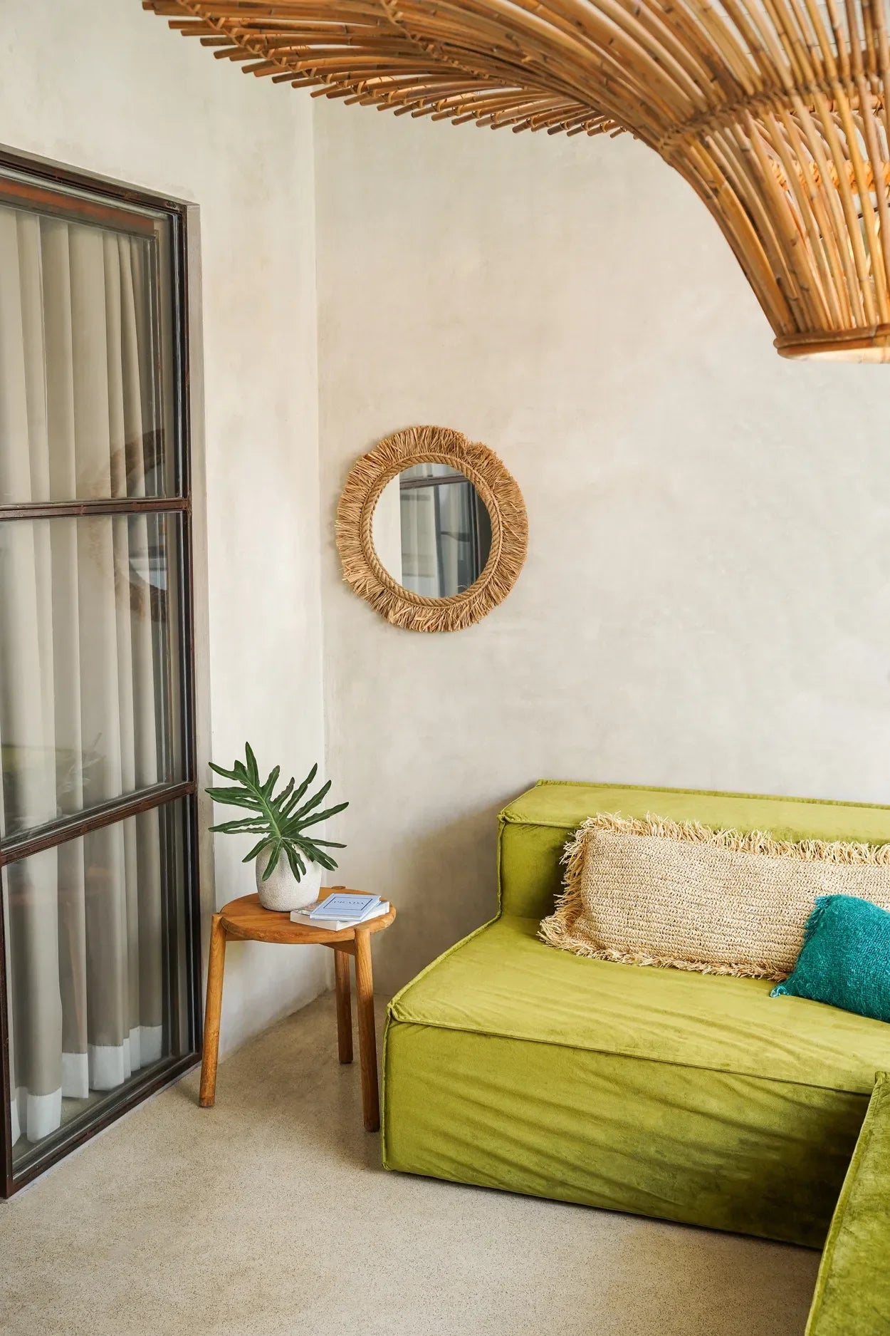 Canapé vert douillet avec coussins décoratifs, idéal pour le Miroir rond en raphia naturel