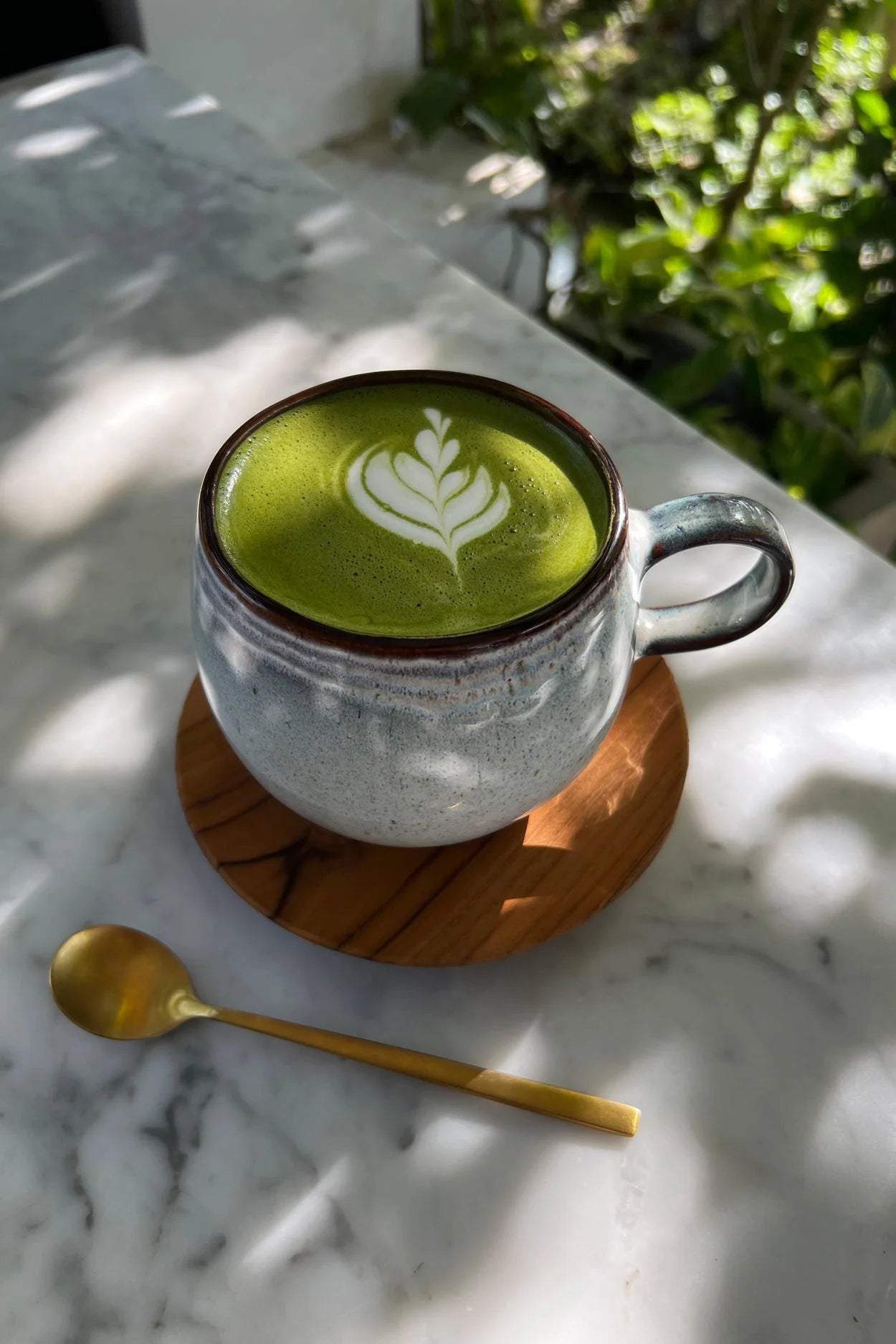 Mug artisanal en grès émaillé vert sauge avec latte matcha et feuille