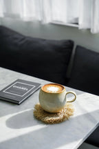 Mug en céramique crème à anse large et bord brun dégradé sur sous-verre tressé