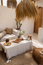 Coin lounge extérieur rustique avec canapé blanc, table de café et décor en fibres naturelles