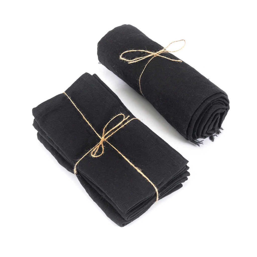 Serviettes en tissu noir roulées et liées avec ficelle naturelle