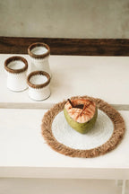 Coconut ouvert sur un tapis à franges pour la natte en raphia d herbe marine blanc naturel