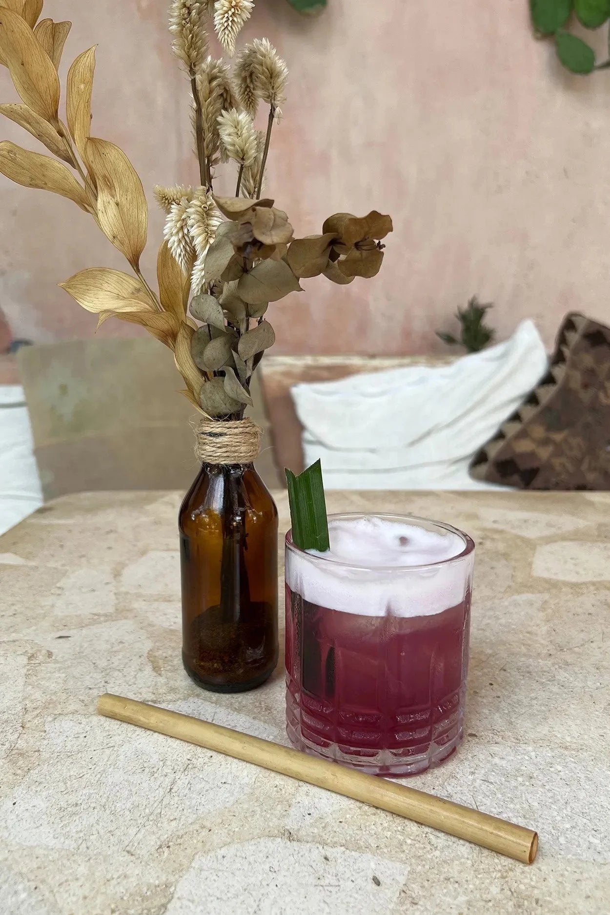 Cocktail violet avec mousse, présentant les pailles réutilisables en bambou naturel avec brosse