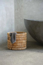 Panier Chuma en osier cylindrique avec serviette grise à l’intérieur