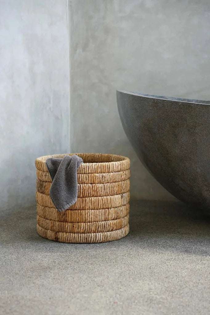 Panier Chuma en osier cylindrique avec serviette grise à l’intérieur
