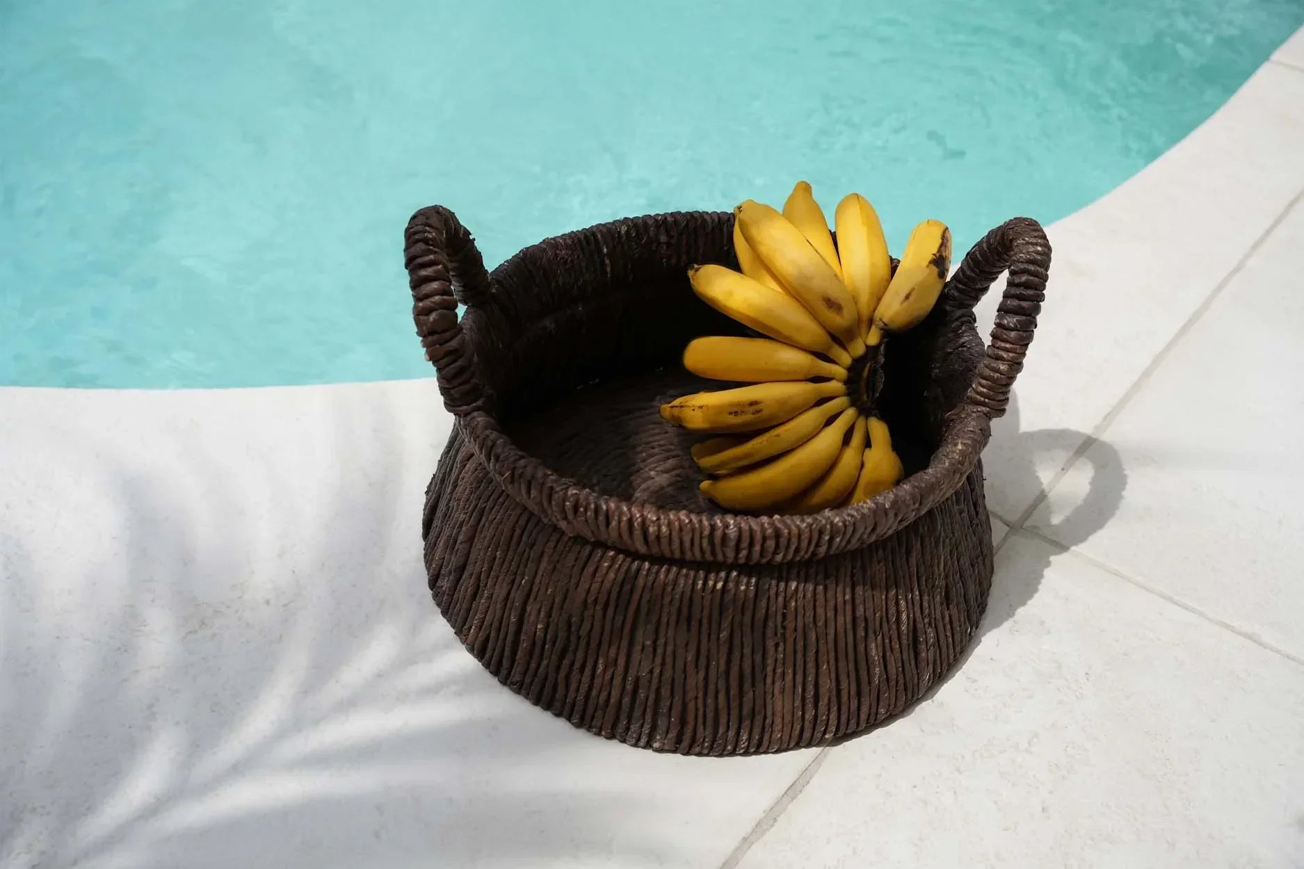 Panier en feuille de bananier tressé avec des bananes jaunes fraîches