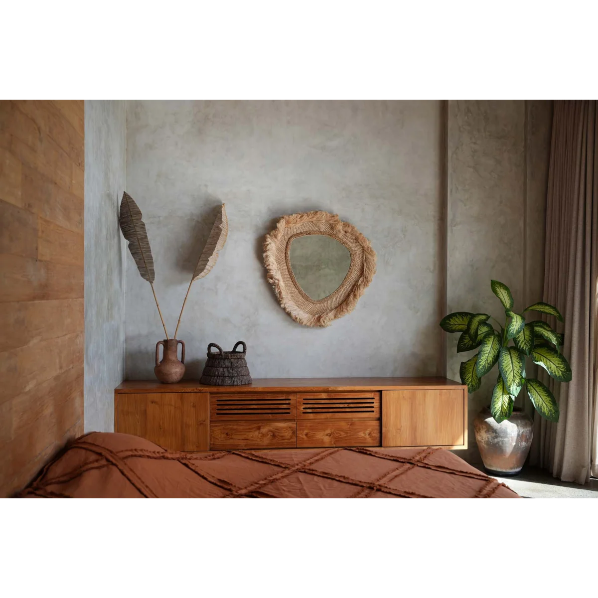 Commode en bois avec miroir tressé et vase triangle en feuilles de bananier