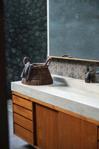 Comptoir en béton avec panier tressé en feuilles de bananier triangulaire et tiroirs en bois