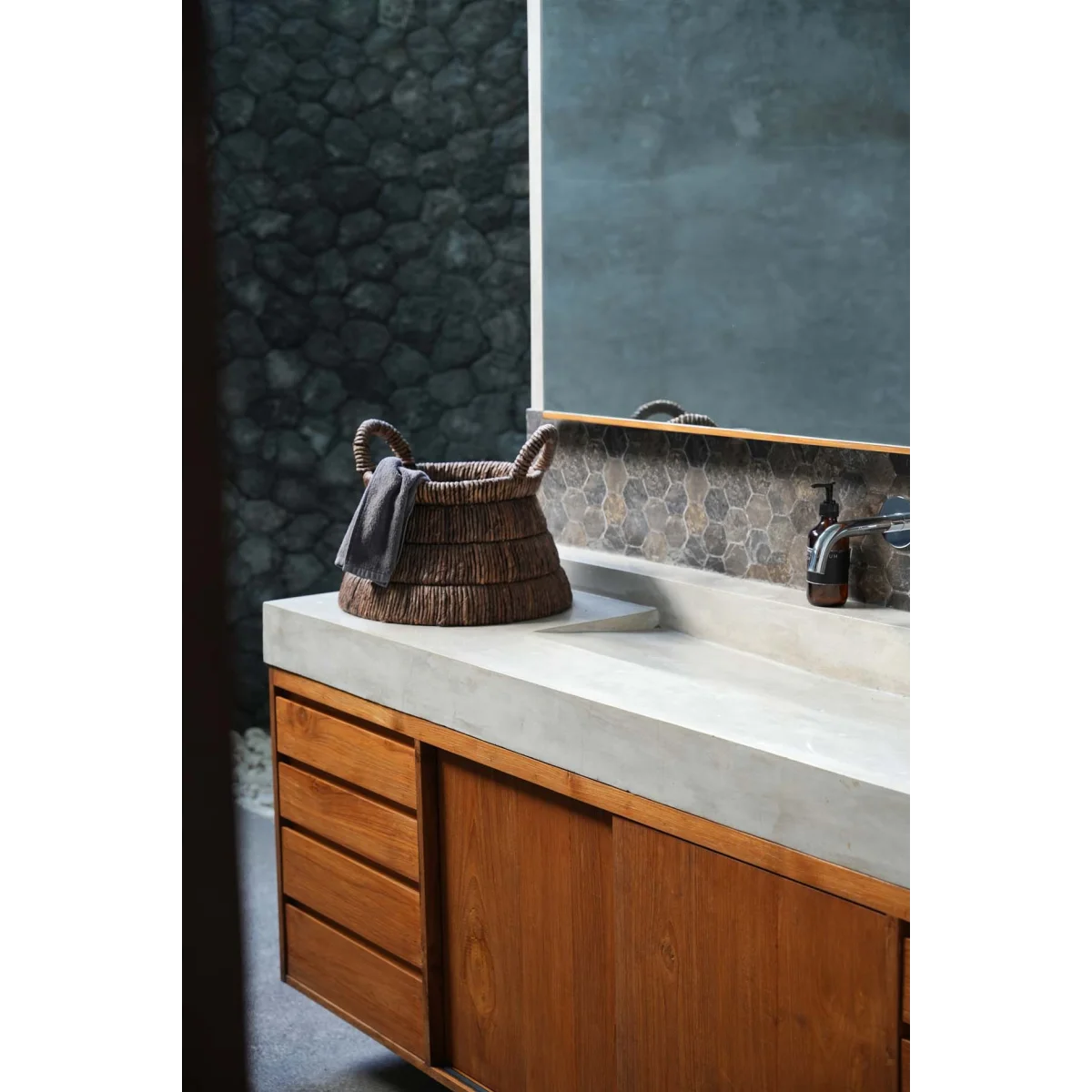 Comptoir en béton avec panier tressé en feuilles de bananier triangulaire et tiroirs en bois