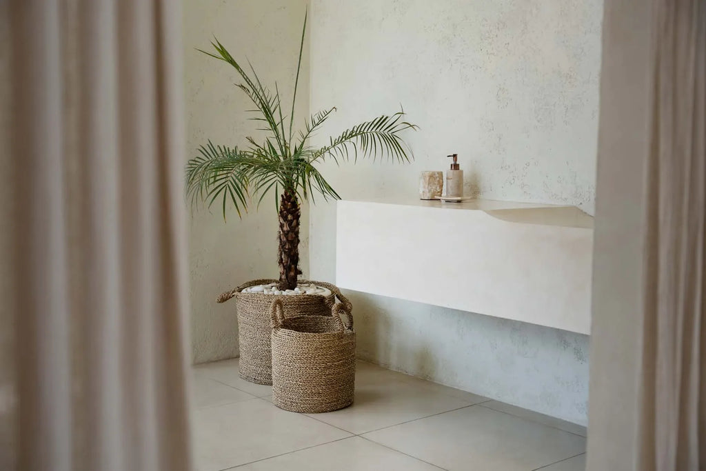 Paniers en herbe de mer tressée naturelle Ø30x34 cm dans une salle de bain minimaliste