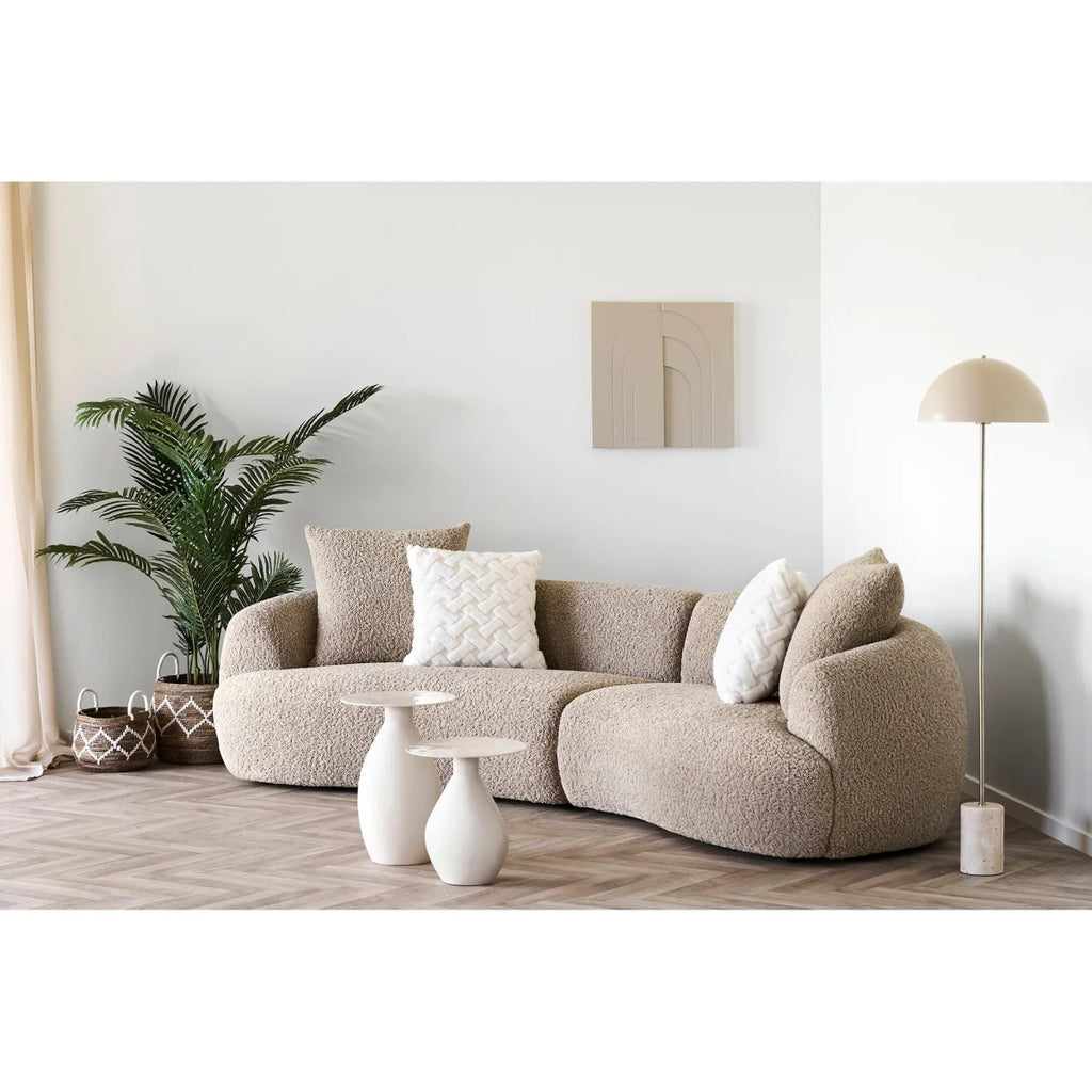 Canapé modulable beige texturé avec coussins, idéal pour salon moderne et confortable