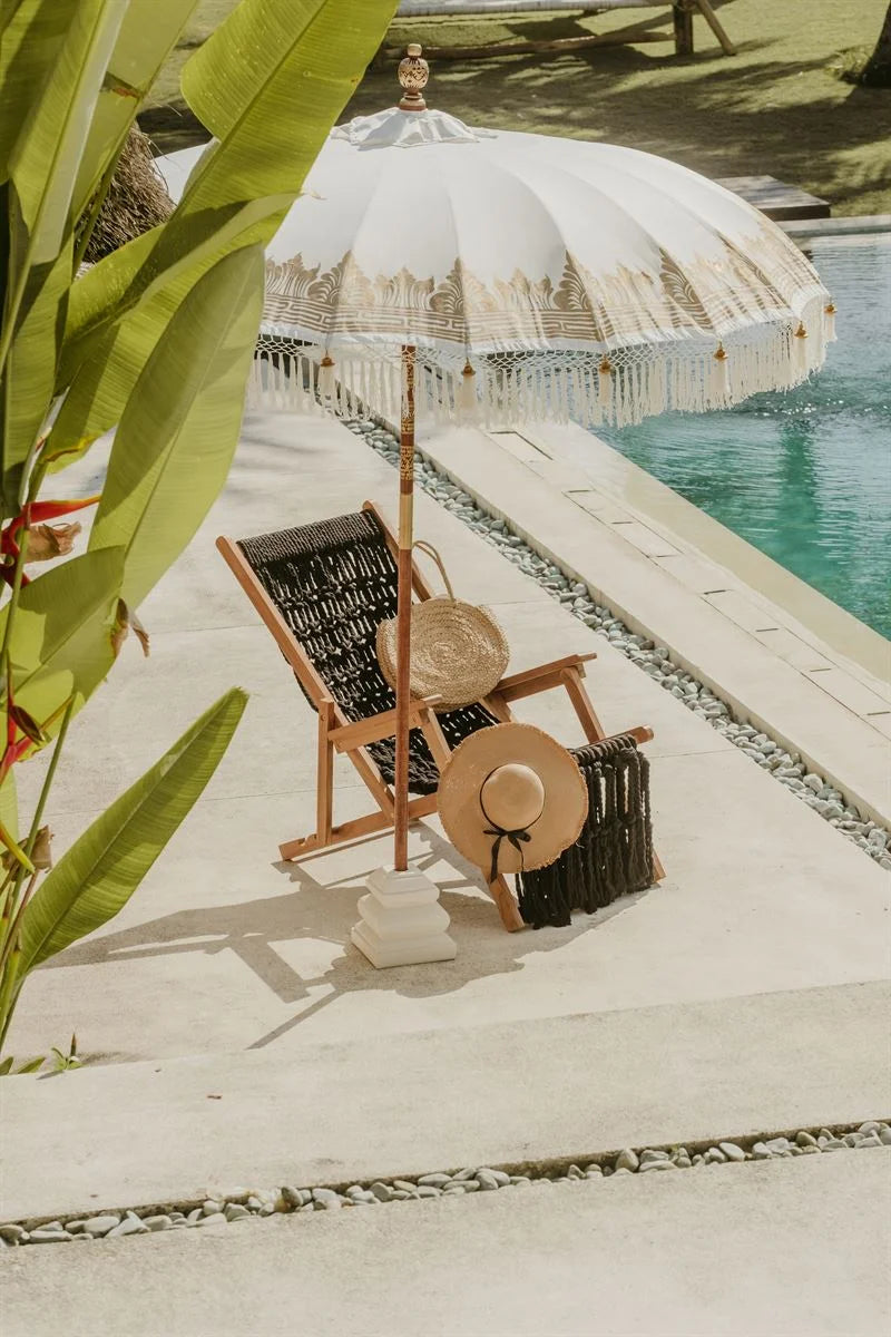 Configuration de détente au bord de la plage avec le Parasol rond crème à franges et dorures