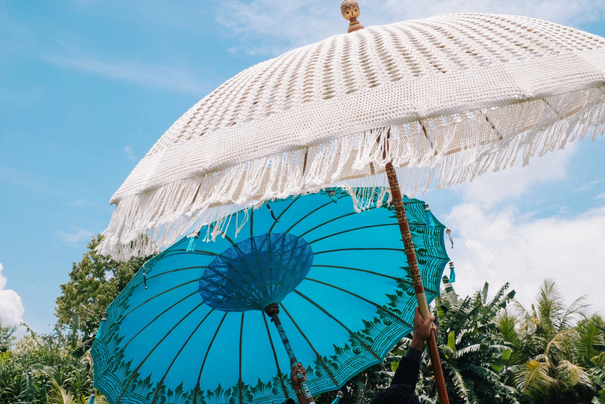 Deux parasols ronds turquoise en tissu décoratif avec franges pour l’extérieur