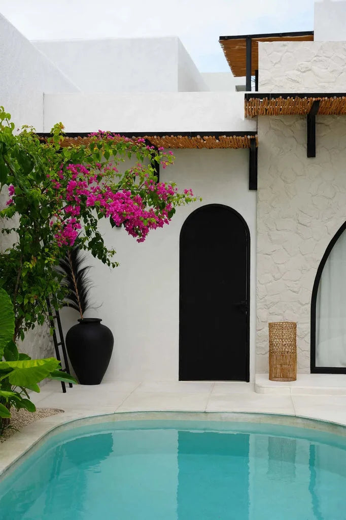 Pendentif Takuhanki Naturel devant une piscine turquoise avec murs blancs