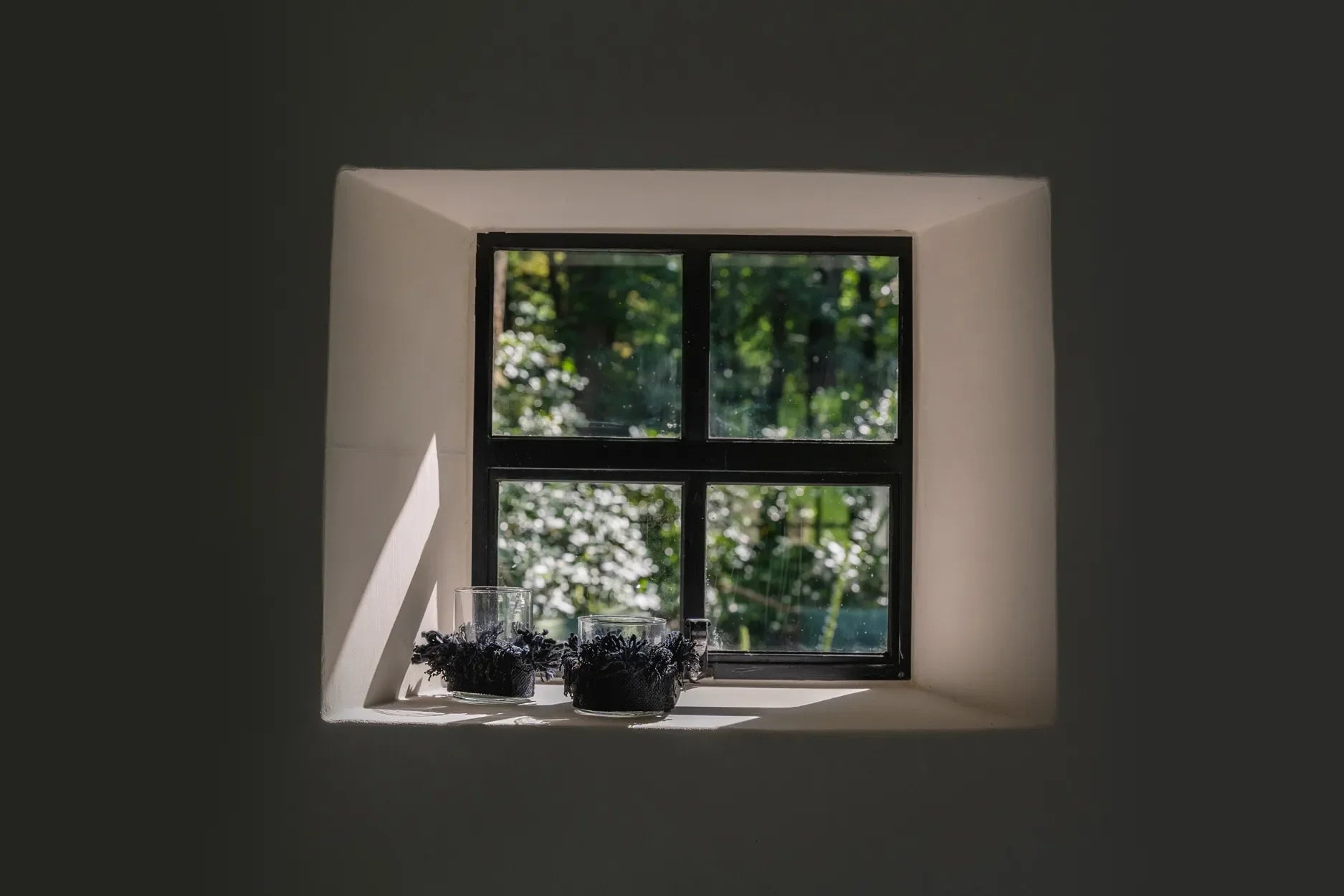 Fenêtre à quatre pans avec des plantes pour un photophore en verre noir velours à franges