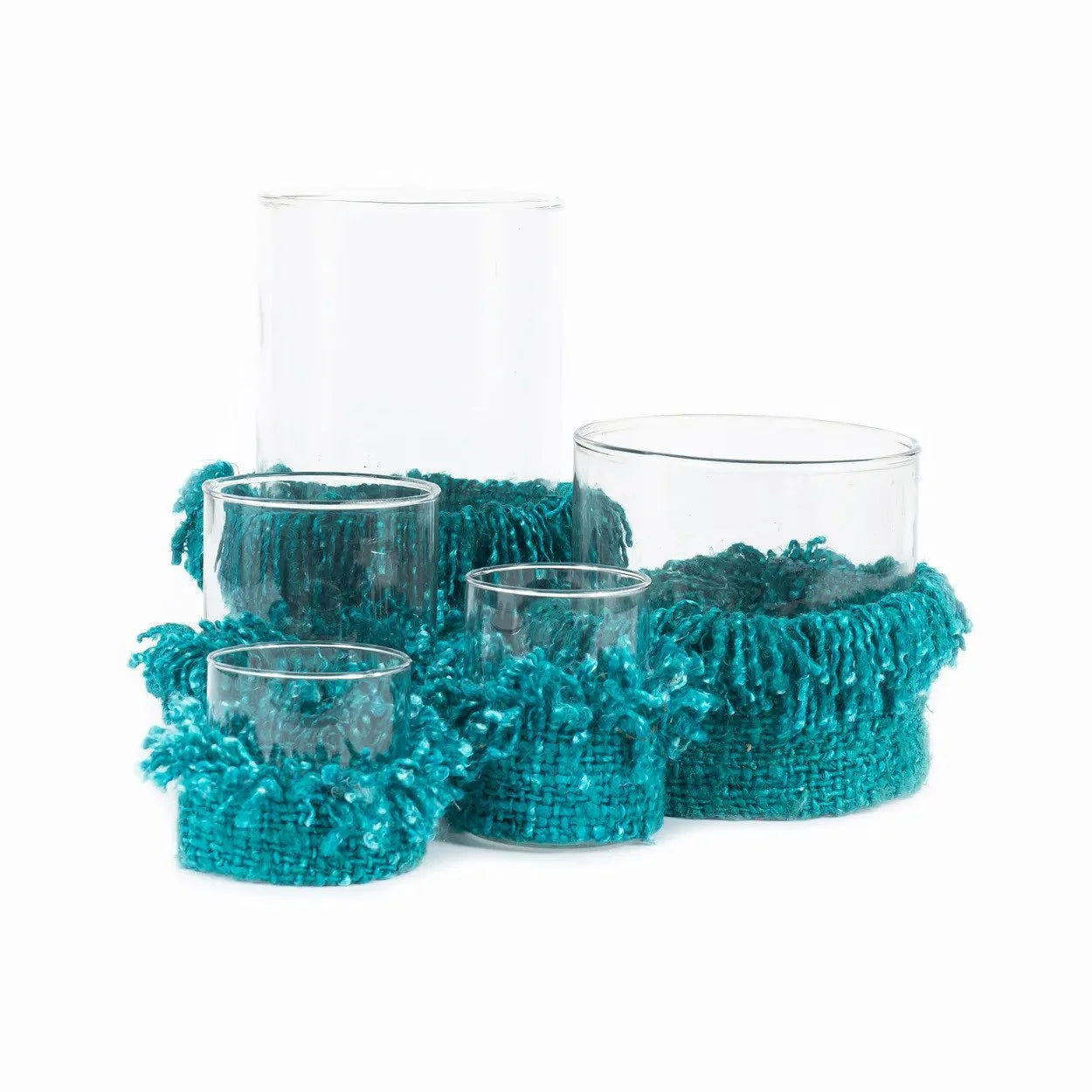 Photophore en verre turquoise avec franges textiles et bougie à l’intérieur