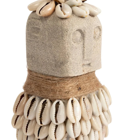 Figure en pierre ornée de coquillages et de ficelle.
