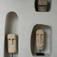 Mur avec niches encastrées présentant des sculptures de têtes en pierre pour La Pierre de Sumba n°21