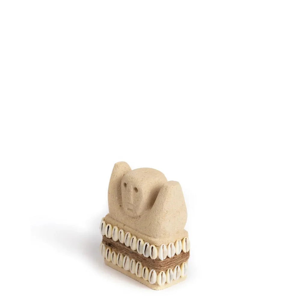Figurine beige avec des accents de cauris.