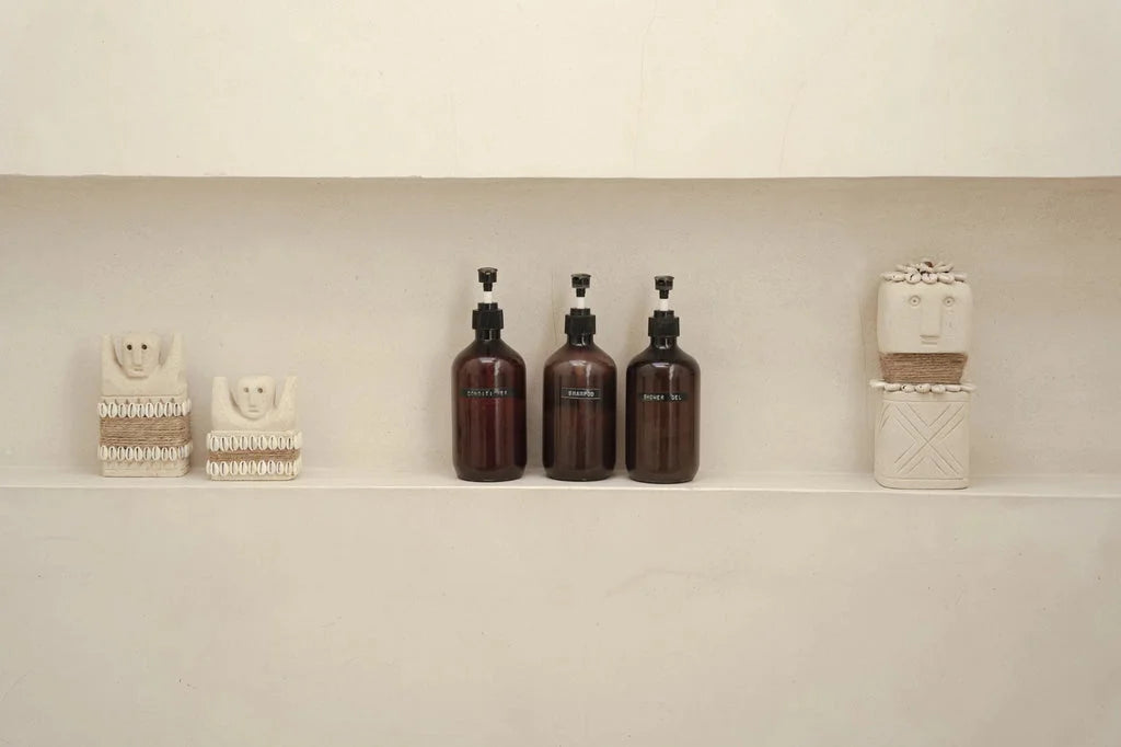 Etagère de salle de bain avec objets décoratifs et flacons de pompe.