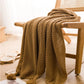 Couverture en laine plaid bohème beige aux franges drapée sur une chaise