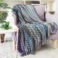 Couverture en zigzag coloré plaid chevron drapée sur un fauteuil gris pour moments cocooning