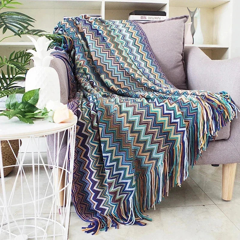 Couverture en zigzag coloré plaid chevron drapée sur un fauteuil gris pour moments cocooning