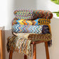 Tasselés et colorés, plaids Chevron sur un tabouret en bois pour des moments cocooning