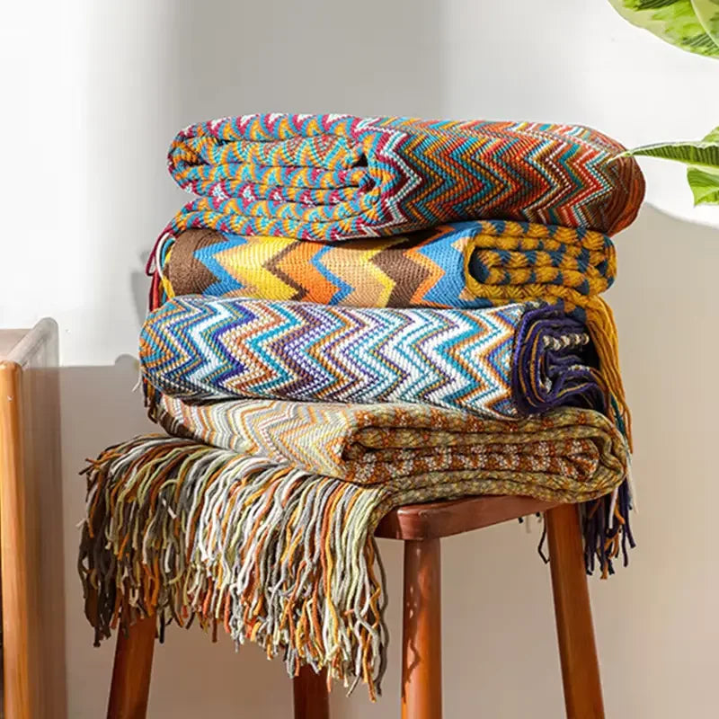 Tasselés et colorés, plaids Chevron sur un tabouret en bois pour des moments cocooning