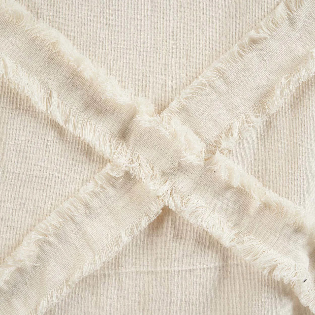 Tissu en lin écru crème avec ruban frangé en forme de X et pompons décoratifs