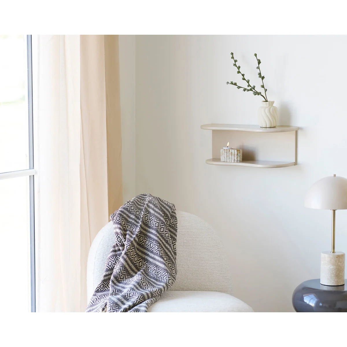 Fauteuil blanc avec plaid en coton recyclé à motifs losanges beige et noir avec franges