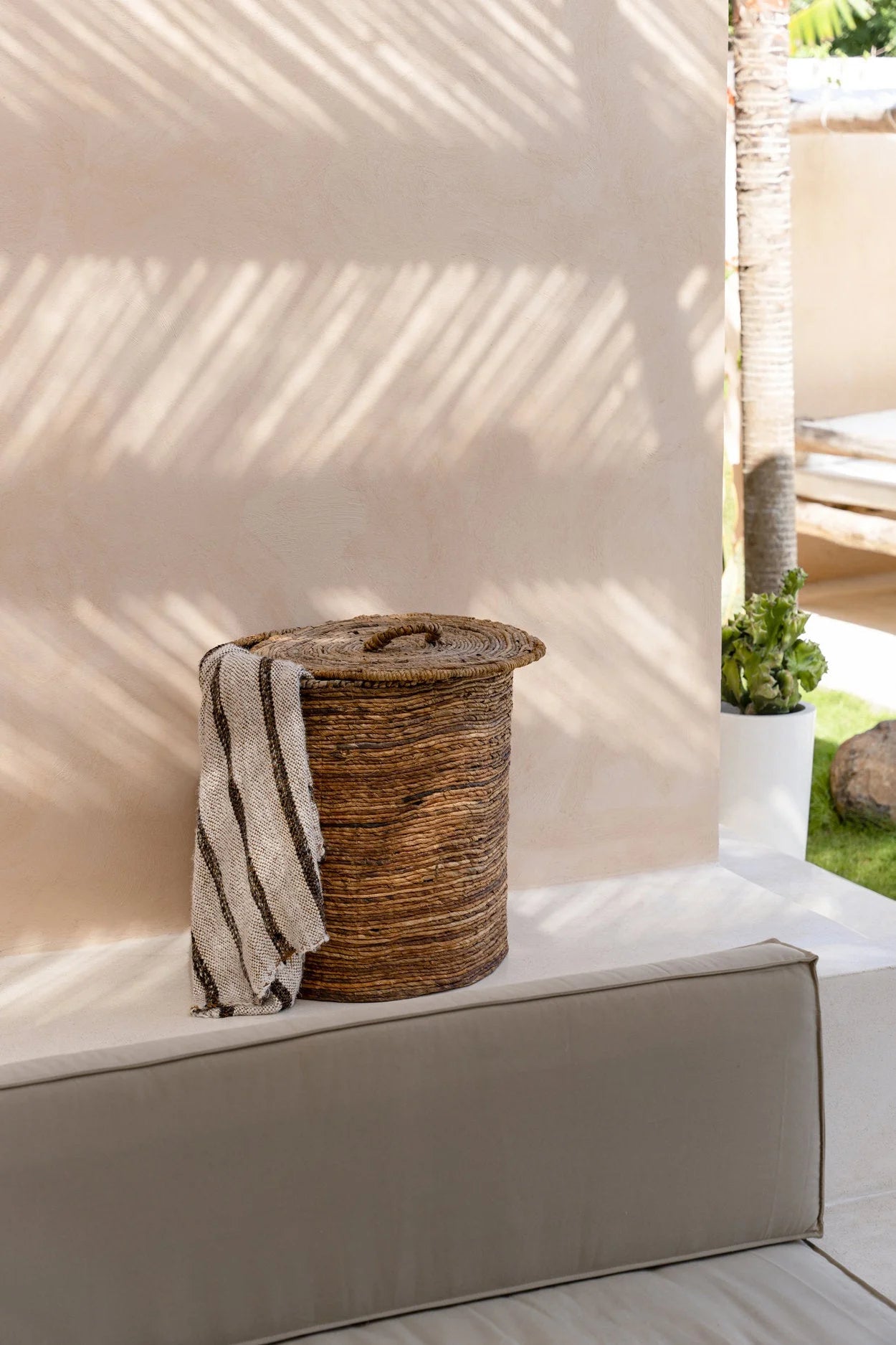Panier tissé avec serviette rayée beige et marron pour rangement élégant