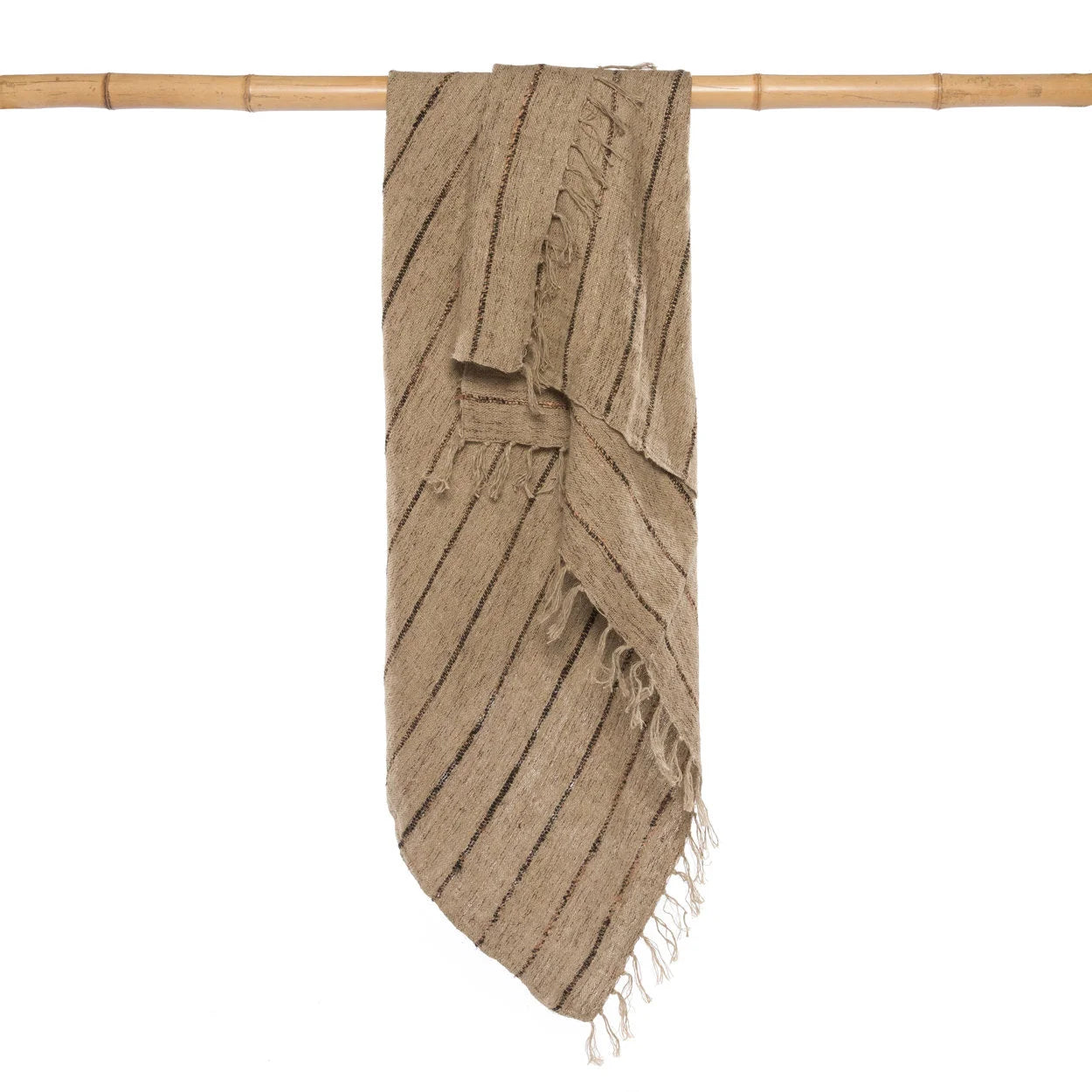 Plaid en coton tissé beige rayé avec franges, suspendu sur une tige en bambou