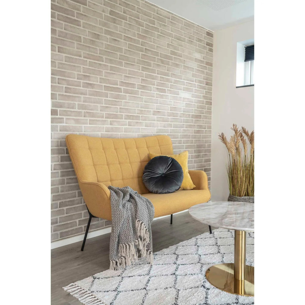 Canapé jaune à touffes, pieds métal noir, couverture grise, plaid coton gris-beige frangé