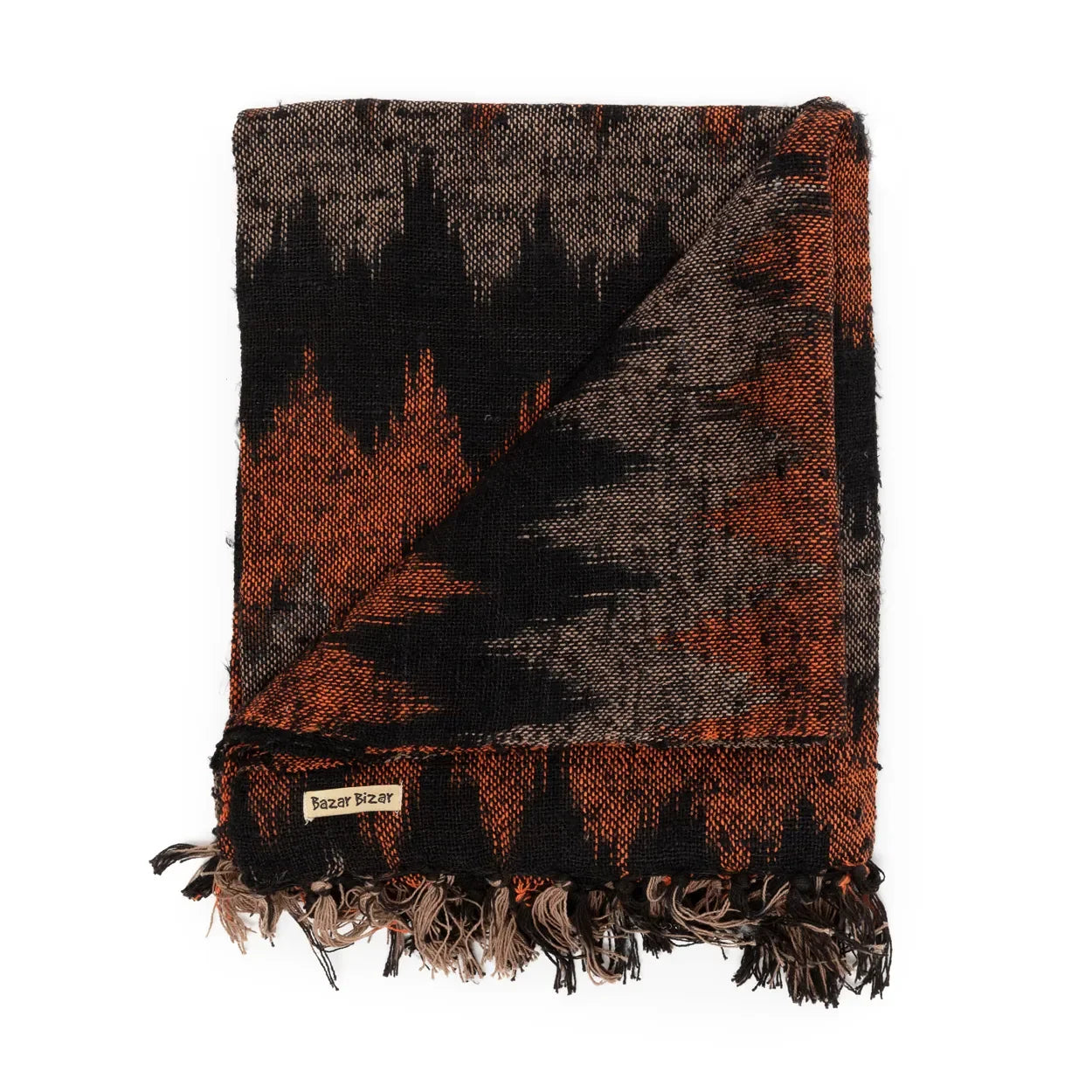 Une couverture en coton tissé noir et orange à motif géométrique avec franges pliée