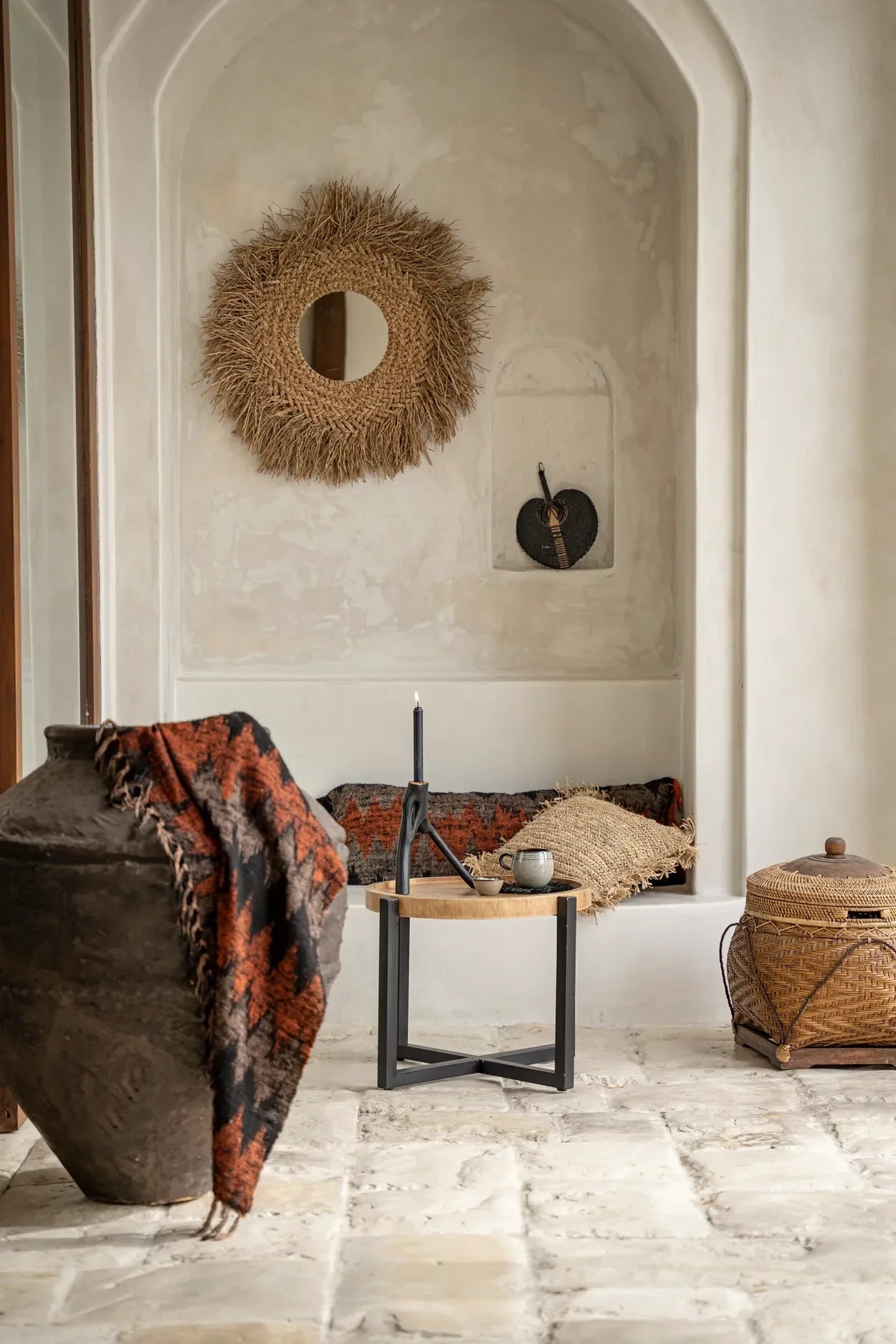 Plaid en coton tissé noir et orange à motif géométrique avec franges dans un intérieur bohème avec niche