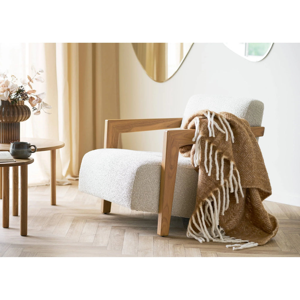 Fauteuil beige cozy en bois avec plaid camel chevron frangé crème