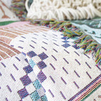 Gros plan sur les motifs géométriques du plaid nordique coloré, tissé en coton et lin