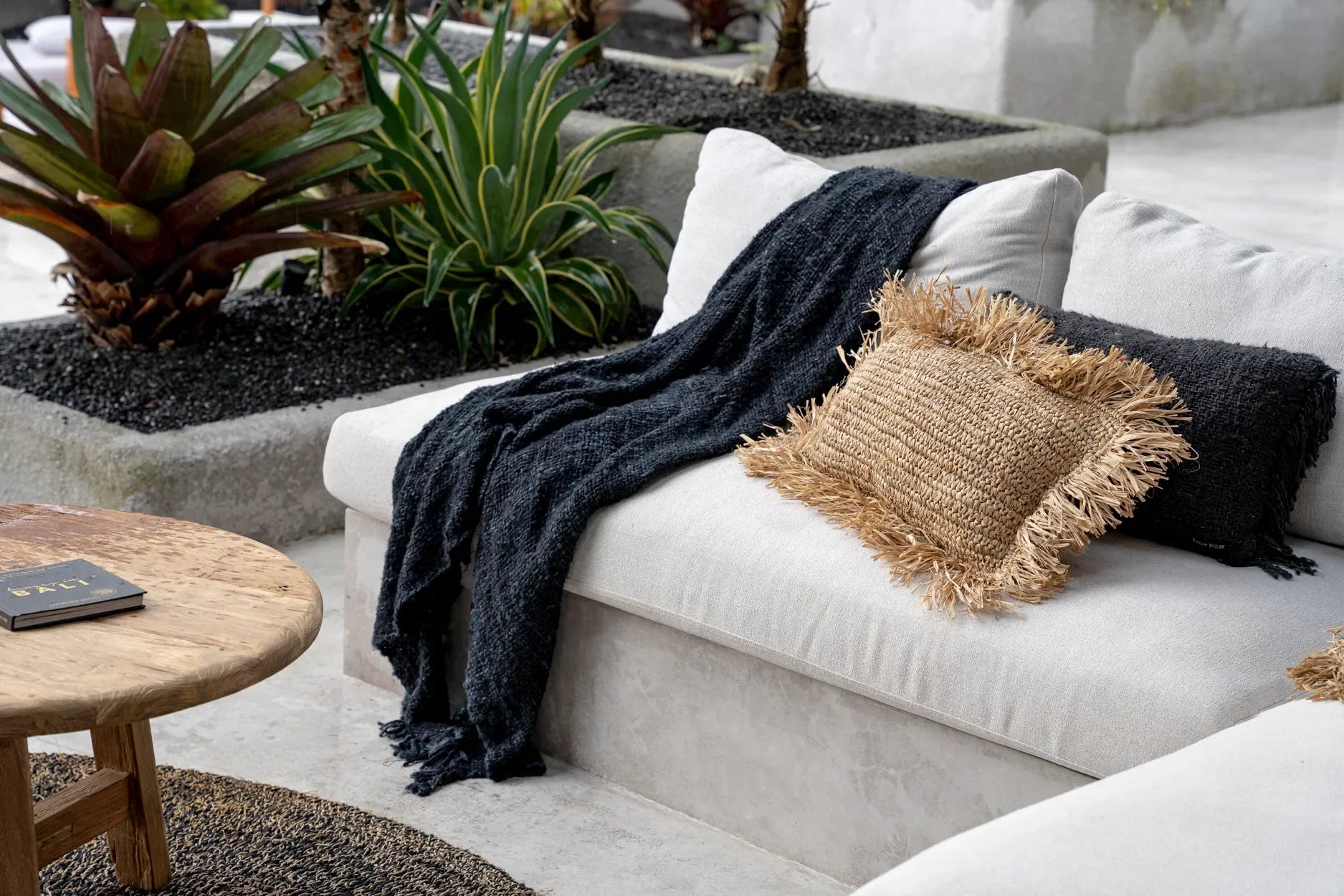 Canapé blanc douillet avec plaid en coton tissé noir et coussins décoratifs