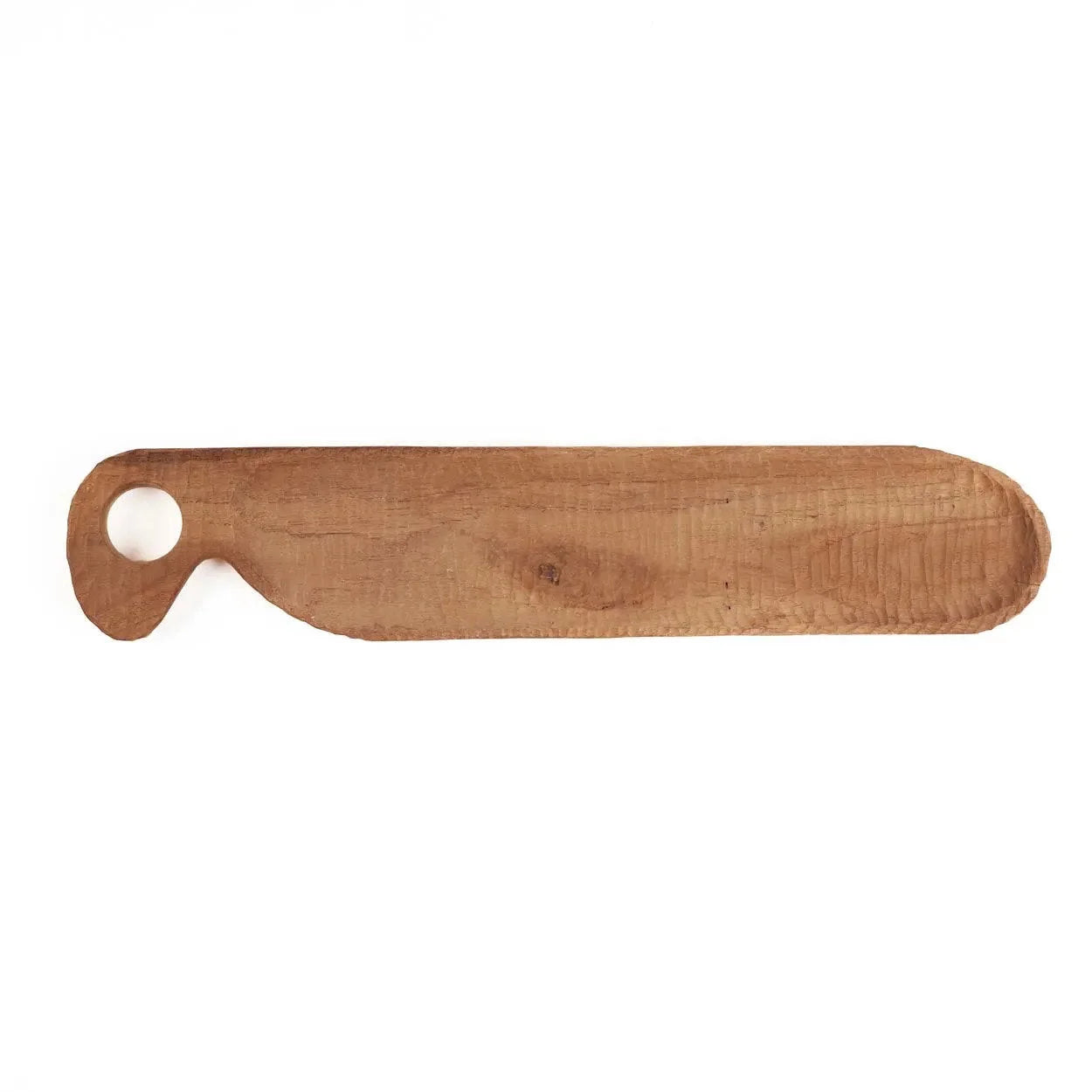 Peigne en bois clair avec extrémité arrondie et trou circulaire, sur une planche à découper en teck massif