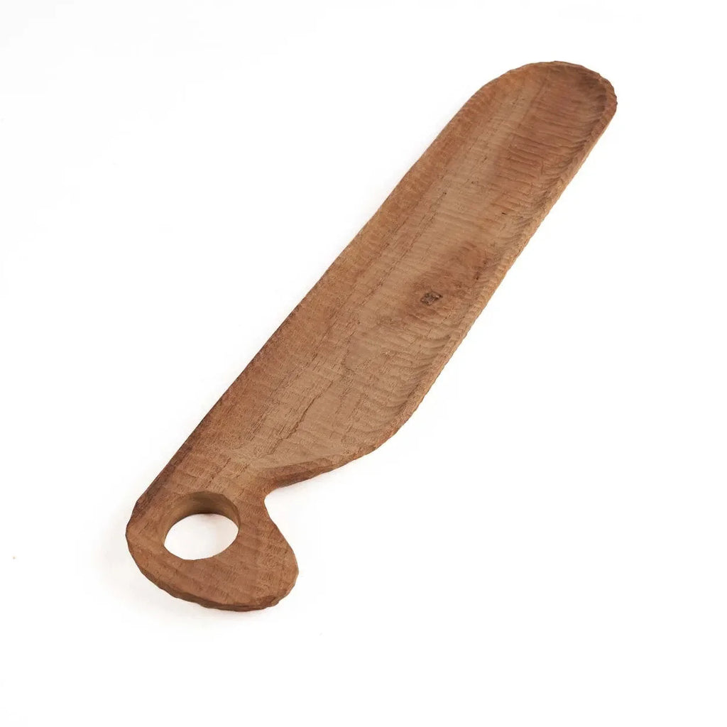 Couteau à beurre en bois avec trou rond dans la poignée sur une planche en teck naturel