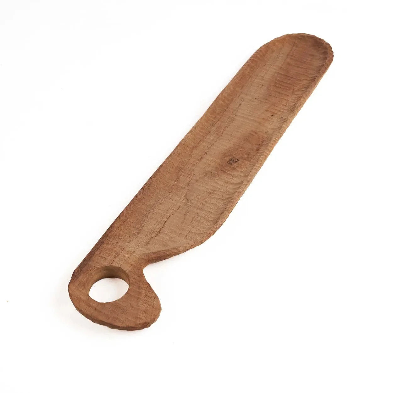Couteau à beurre en bois avec trou rond dans la poignée sur une planche en teck naturel