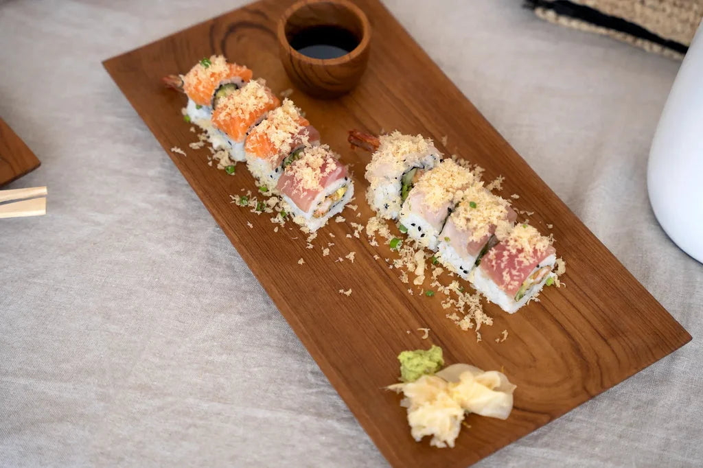 Sushis rolls sur une planche en teck pour la plaque à sushis en racine de teck L