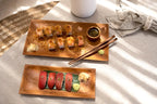 Sushi artistiquement disposé sur une grande plaque en racine de teck
