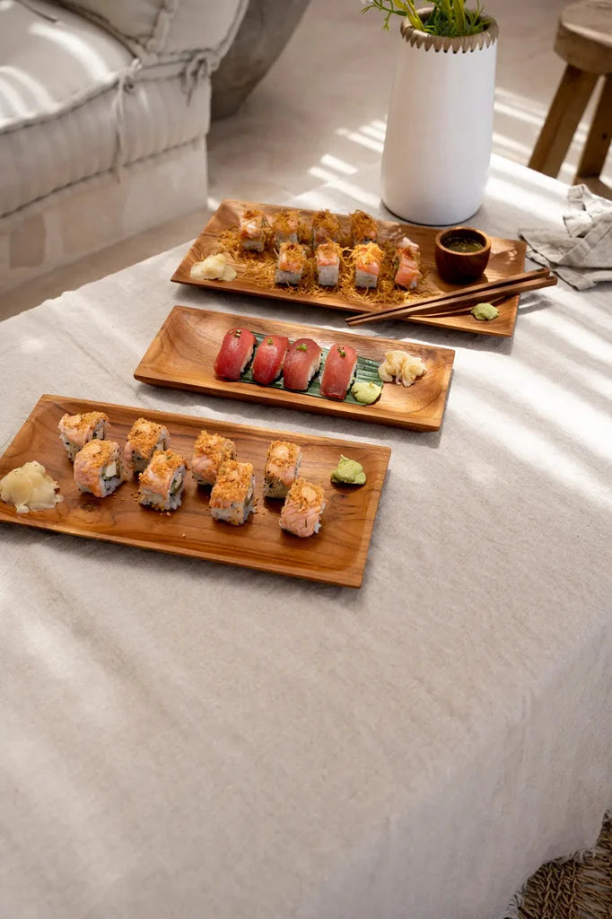Plateaux de sushis sur une table avec la plaque à sushis en racine de teck S