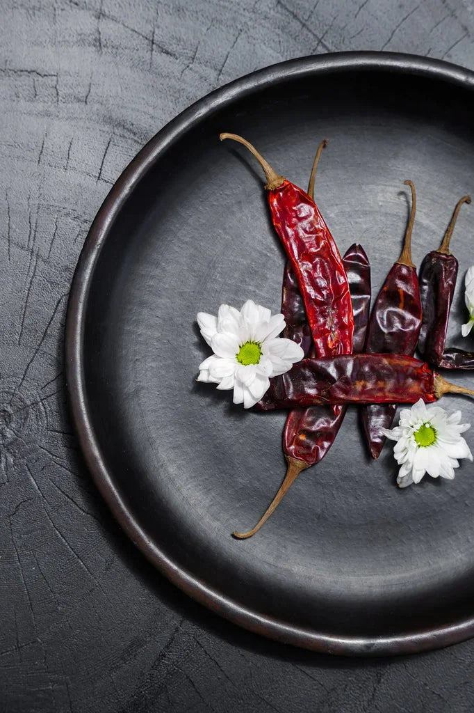 Chili sec avec fleurs blanches sur le produit La plaque classique brûlée Noir M