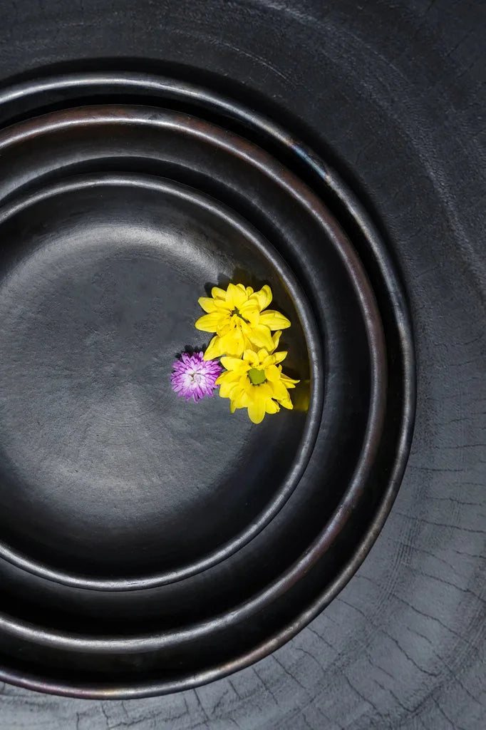 Bols concentriques noirs avec fleurs.